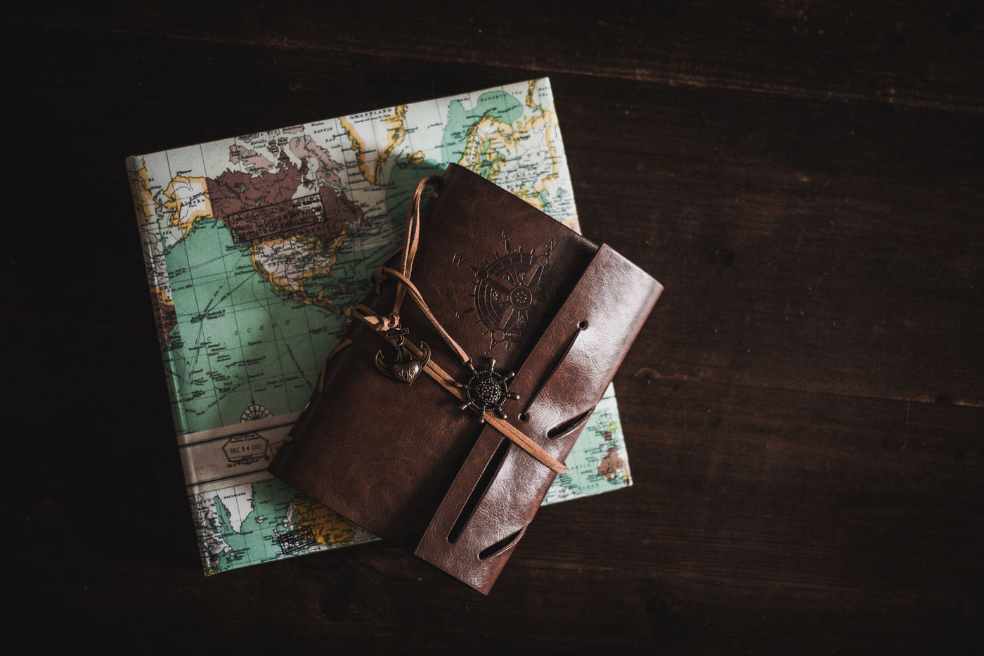 A leather travel journal resting on an old map